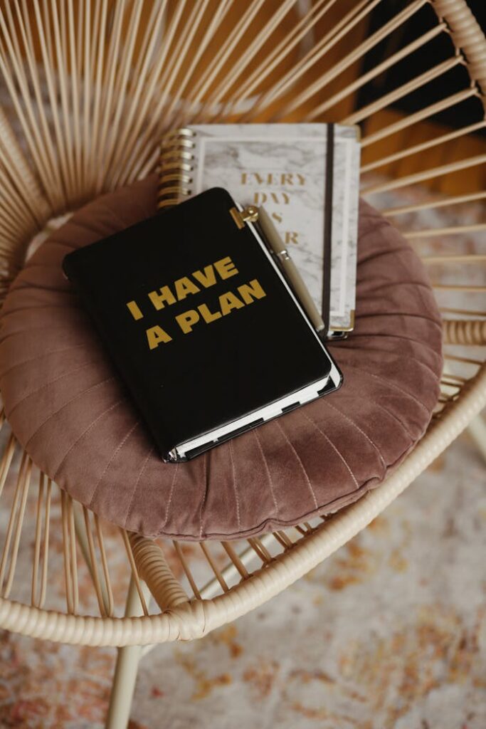 pexels-photo-5546831 A stylish journal titled 'I Have a Plan' on a plush chair, inspiring organization and productivity.