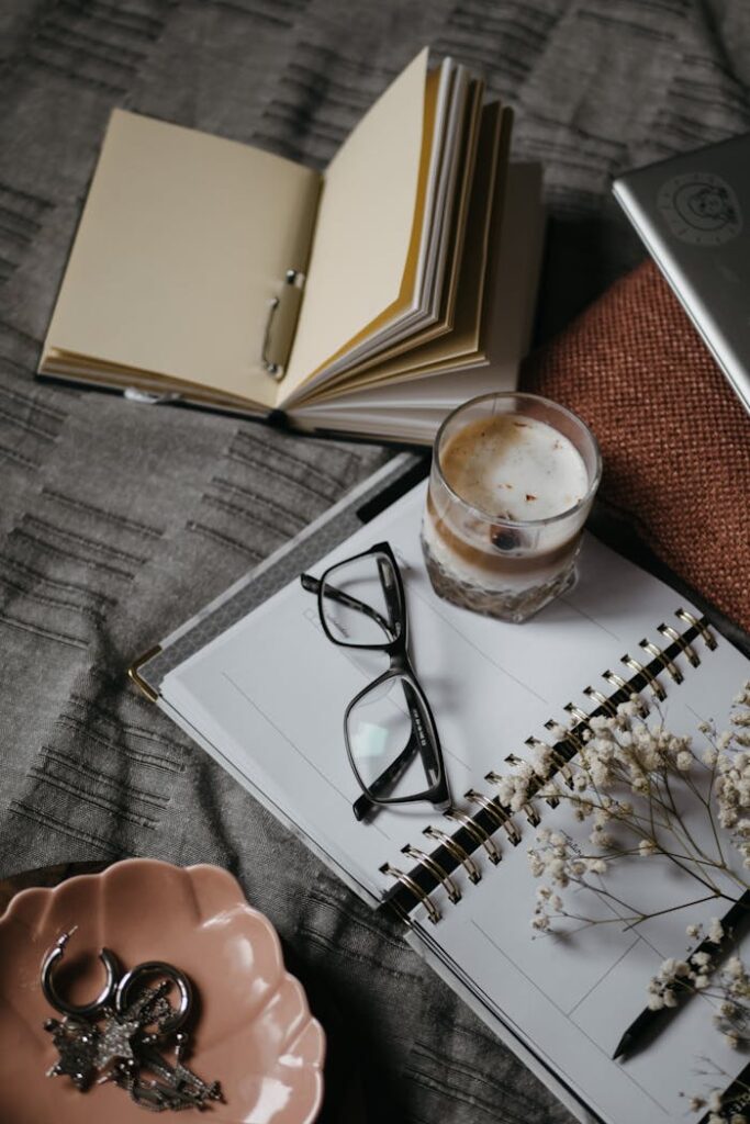 pexels-photo-5546892 A warm and cozy home workspace featuring a notebook, coffee, and reading glasses.